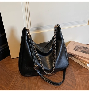 Detail of vintage matte black tote with gold chain and adjustable leather strap
