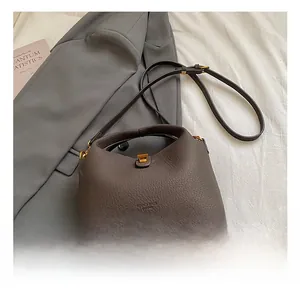 Détail du sac à main en cuir grainé marron foncé avec boucle métallique dorée élégante