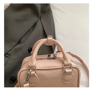 Détail du petit sac carré rose en cuir PU texturé avec fermeture éclair argentée fine