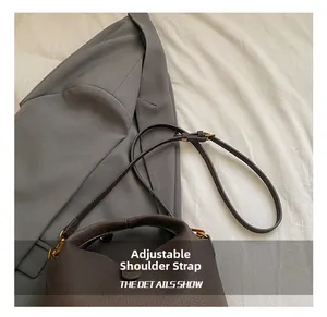 Détail de la bandoulière réglable en cuir marron avec boucle en métal doré