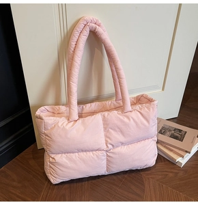 Detail view of pink quilted puffer tote bag showing soft fabric texture and stitched handles