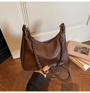 Detail view of the vintage coffee Hobo bag with bronze chain strap and smooth zipper closure