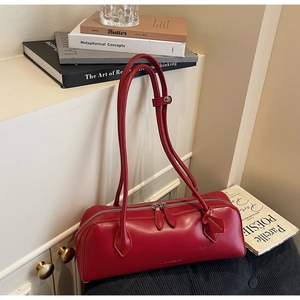 Detail of red French retro cylinder bag showing the glossy leather texture and metal zipper