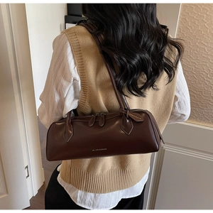 Detail of a vintage dark brown baguette bag with double zipper and slim shoulder strap