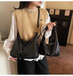 Detail view of black faux leather tote set with gold chain and matching small handbag