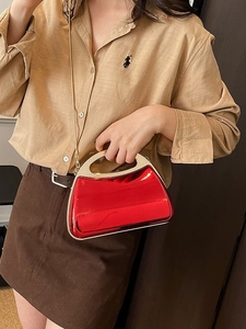 Glossy red acrylic half-moon evening bag with golden metal handle and chain strap