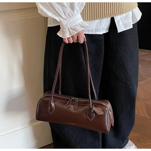 Detail of a dark brown vintage baguette bag with dual zippers and long shoulder straps