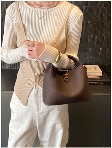 Détail du sac seau en cuir grainé marron foncé avec élégant fermoir rotatif doré de luxe