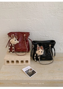 Close-up of diamond quilted bucket bags with chain straps and plush bear pendants