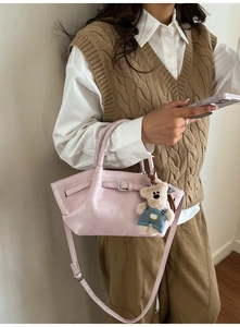 Pink leather bucket bag detail with decorative silver buckle and cute plush bear charm