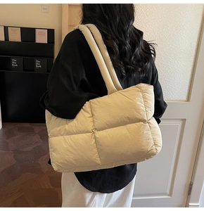 Close-up of the quilted puffy tote bag texture in off-white nylon with large capacity