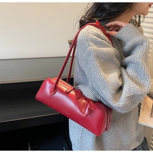 Detail of red leather long barrel shoulder bag showing texture and daily wear proportions