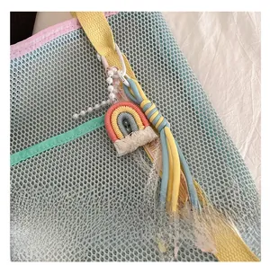 Détail du pendentif arc-en-ciel tissé avec perles et glands sur un sac fourre-tout bleu