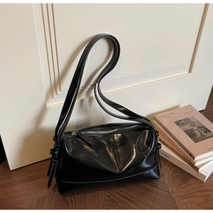 Detail of glossy black shoulder bag with silver zipper and smooth leather texture