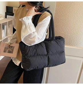 Lifestyle shot of a black quilted puffer tote bag with wide straps for daily commuting