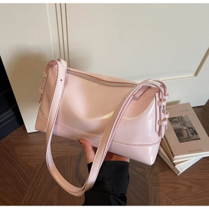 Close-up of a light pink shoulder bag with a glossy finish and silver zipper detail