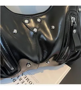 Detail of black glossy leather bag with silver rivets and vintage punk aesthetic