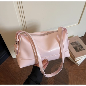 Detail of light pink PU leather shoulder bag with smooth texture and metal buckle