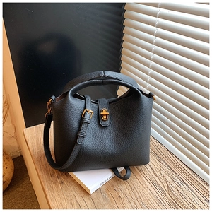 Vue détaillée du sac seau noir en cuir litchi avec fermoir doré et poignée ronde