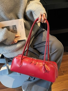 French minimalist red dachshund baguette bag worn by a model in a cozy indoor setting