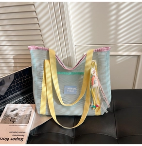 Gros plan détaillé d'un sac cabas en maille colorée avec un pompon décoratif et perles