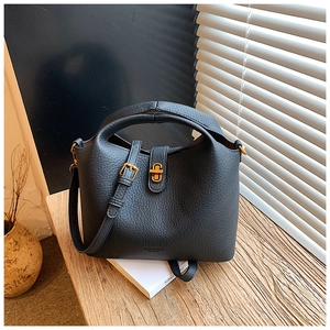 Détail du sac seau en cuir grainé noir avec fermoir doré et logo de haute qualité