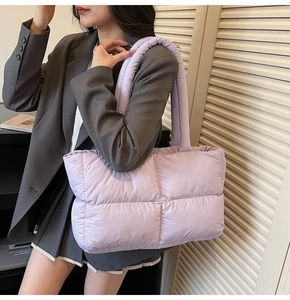 Close-up of quilted puff tote bag in light purple with wide padded shoulder strap
