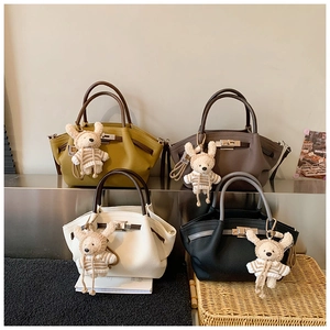 Detail view of retro leather handbags in four colors with cute knitted bunny charms