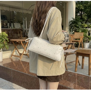 Sac baguette crème chic avec imprimés étoiles grises et cordons latéraux à l'épaule