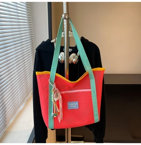 Détail du sac cabas en maille colorée avec poignées vert menthe et ruban arc-en-ciel