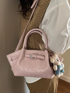 Pink bucket handbag with teddy bear charm shown by model for a trendy commute look
