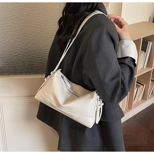 Detail view of the sleek cream white faux leather tote bag with stylish side buckle design