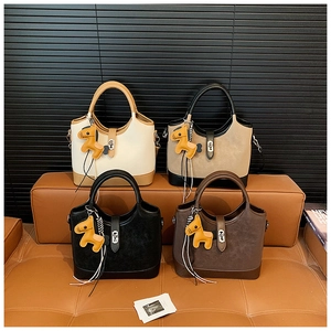 Detail showing four bucket bags in various colors with cute horse charms on a leather sofa