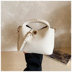 Détails du sac seau blanc à motif litchi avec fermoir doré et bandoulière fine