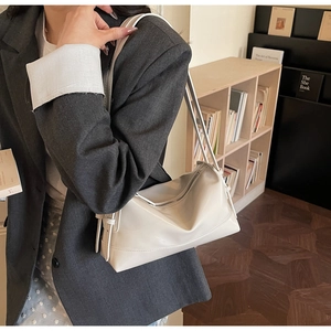 Detail of minimalist cream PU leather tote bag with metallic zipper and soft texture