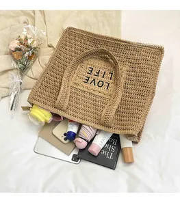 Vue détaillée du grand sac cabas en paille montrant l'espace intérieur pour divers objets