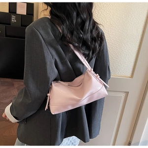 Detail view of pink PU leather baguette bag showing texture and tassel on shoulder