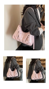 Close-up of pink hobo shoulder bag featuring silver studs and metal triangle plaque