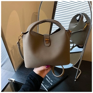Détail d'un sac seau en cuir grainé de qualité avec fermoir rotatif doré et anse élégante