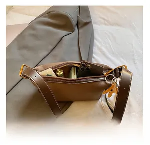 Détails de l'intérieur d'un sac à bandoulière en cuir marron avec sa grande capacité