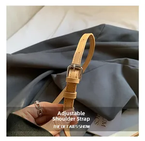 Close-up of light brown leather adjustable strap with silver buckle and fine stitching