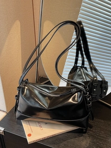 Minimalist black glossy leather shoulder bag with a high-shine finish and dual thin straps