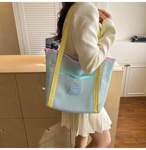 Détail du sac fourre-tout bleu en résille avec bandoulières jaunes et bordures roses