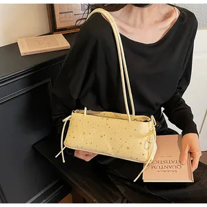 Sac baguette jaune clair à imprimé étoilé présenté dans un décor intérieur vintage