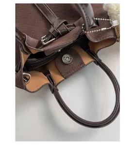 Detail view of large capacity woven bucket bag featuring magnetic closure and inner zipper pocket