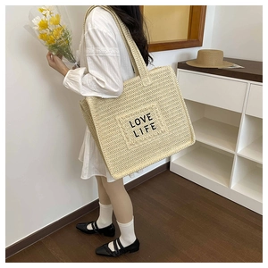Détail du sac en paille tissé main avec broderie LOVE LIFE et poche extérieure