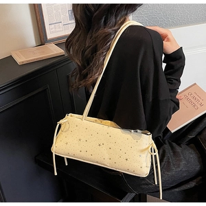 Détail du sac à bandoulière jaune clair à imprimé étoiles avec nœuds et fine lanière