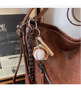 Detail of vintage baseball pendant set with mini wooden bat and glove on leather tote bag