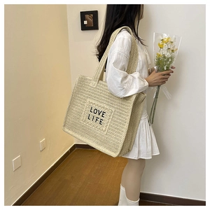Détail du sac cabas en paille tissé avec broderie Love Life noire pour les vacances