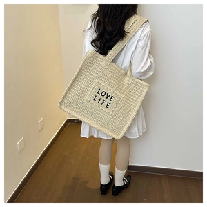 Détail du grand sac cabas en paille avec broderie LOVE LIFE et doubles anses de transport